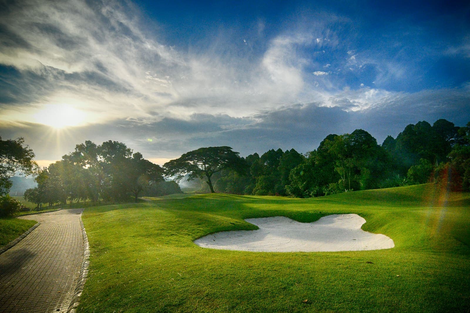 Sunrise over a fairway and bunker on the championship course
