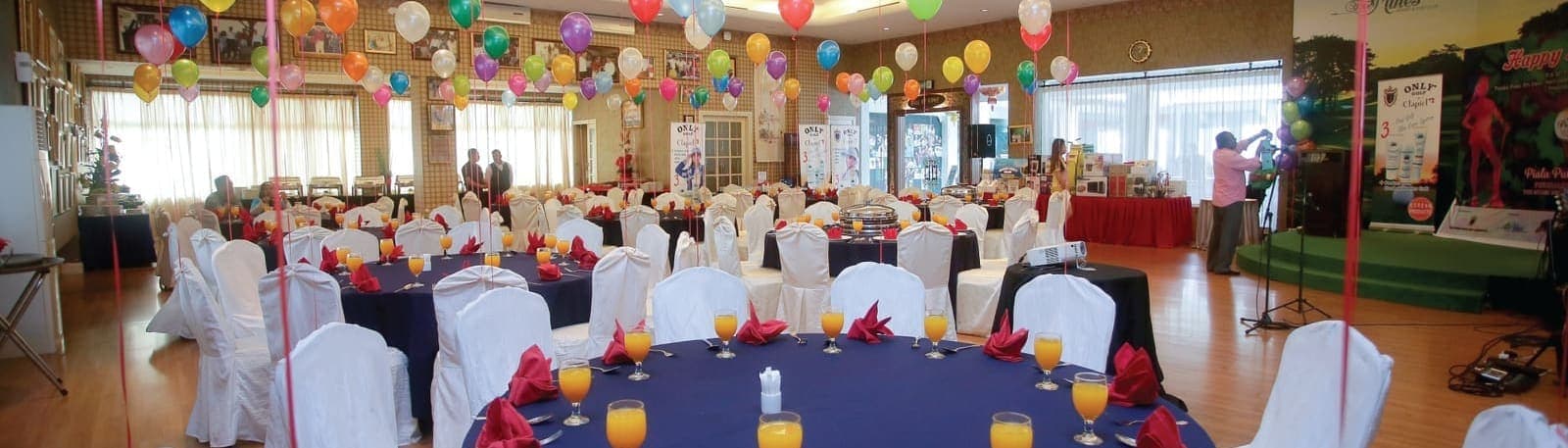 The ballroom decorated with balloons and round tables set for a function