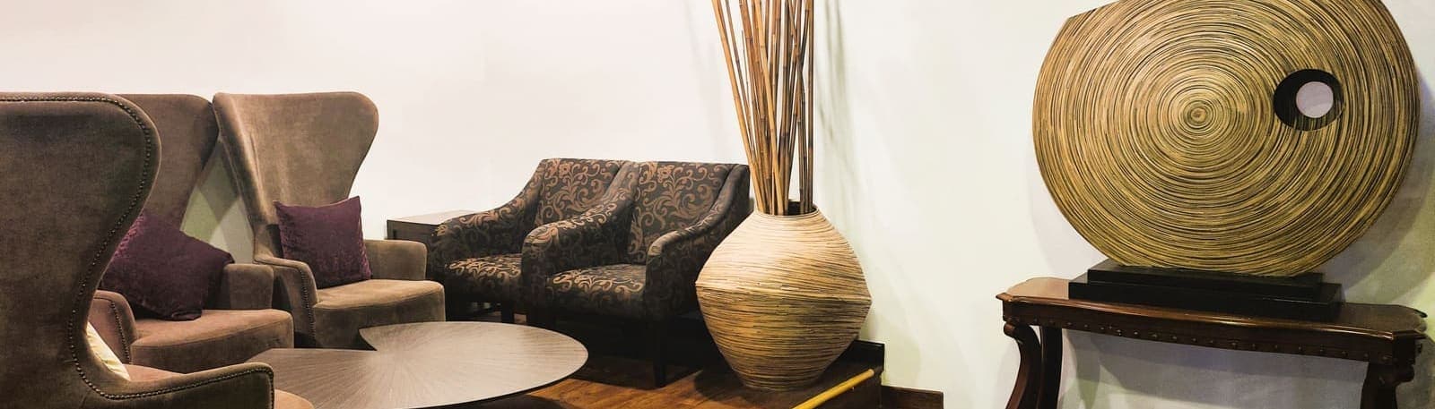 A spa lounge with velvet armchairs and a woven decorative vase