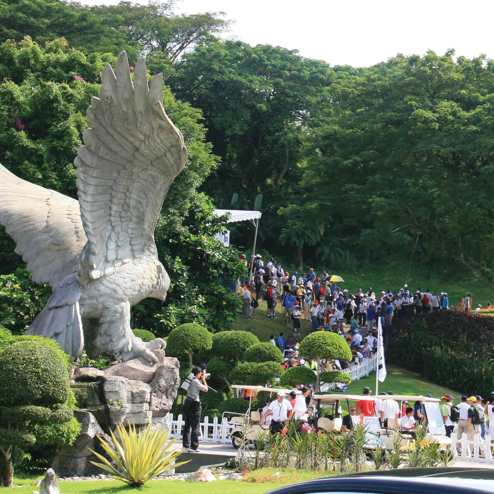 The club's eagle statue overlooking a fairway lined with tournament spectators and golf carts
