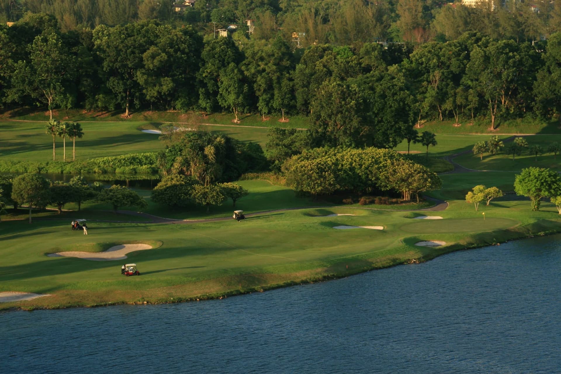 The championship fairway curving toward the mine lake, framed by mature trees